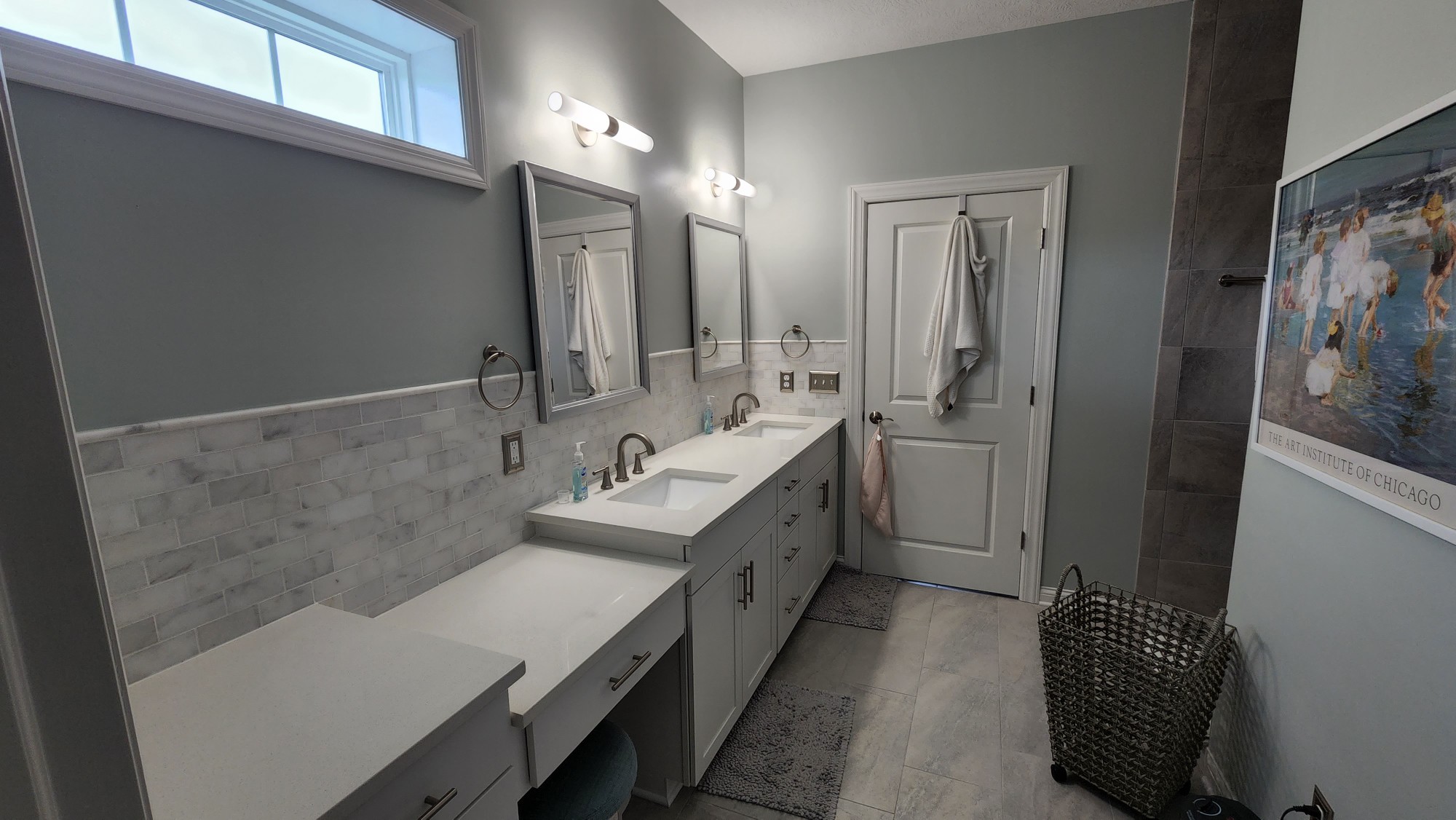 Finished double vanity with marble subway backsplash, quartz top and tiled shower wall
